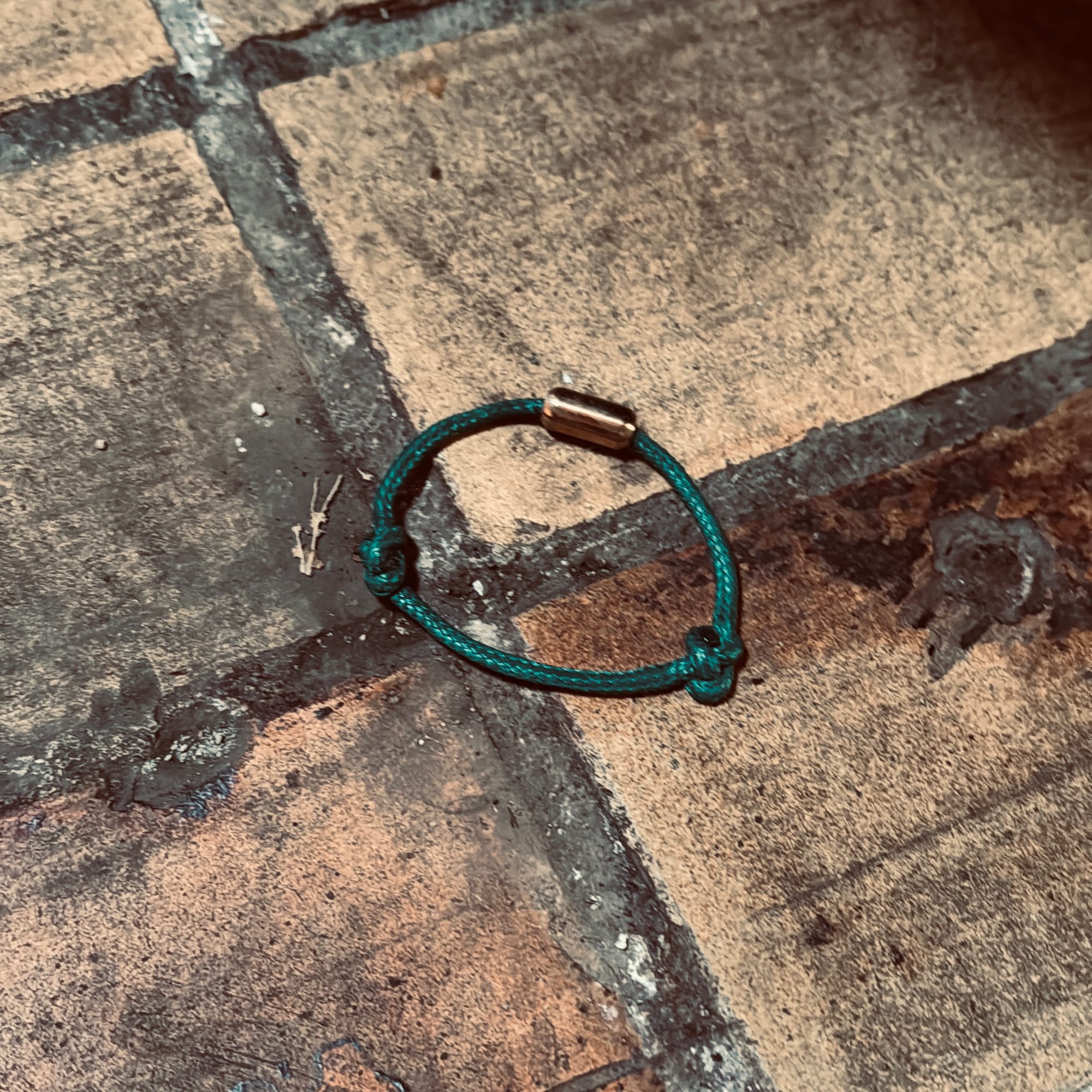 Ein grünes Armband liegt auf dem Boden